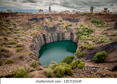 Wide View Of The Big Hole In Kimberley, A Result Of The Mining Industry, With The Town Skyline On The Edge