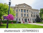 Wide view of Dekalb County Court House with flowers on summer day with clock nearing noon