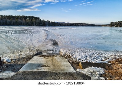 Wide View Of Ice Covered Norton Pond In Lincolnville Center Maine As Seen From A Boat Ramp With A Fishing Shack In The Distance.