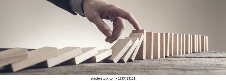 Wide View Image Of Businessman Hand Stopping Collapsing Dominos With His Finger. Conceptual Of Business Strategy And Solution.