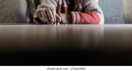 Wide View Image Of Senior Man Counting His Last Euro Coins In A Conceptual Image Of Lack And Poverty.