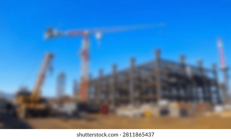 A wide view of a massive construction project featuring multiple tall cranes and the intricate steel skeleton of a new building under a bright blue sky.