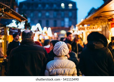 Wide View Of Tourist Walking At The Christmas Market In France, Strasbourg - People Admiring The Art Toys And Drinking Mulled Wine 