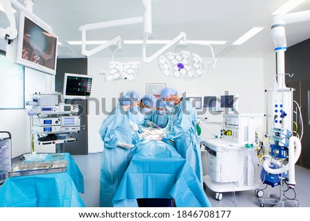 A wide view of a truly modern operating room a with a team of surgeons performing an operation