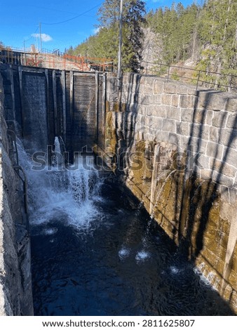 Wide view of Vrangfoss Lock on the Telemark Canal in Telemark, Norway, featuring historic stone lock walls, wooden sluice gates and flowing water.