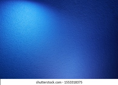 A wide volume beam of light blue on a blue texture background