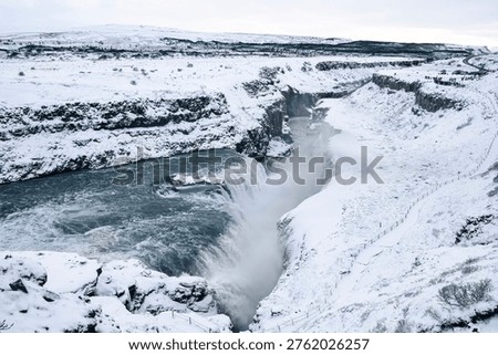 Wide winter view of Gullfoss waterfall and snowy canyon in Iceland.