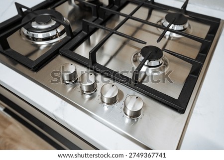 Wideangle Gas Range With Grates And Control Panel Highlighting Polished Stainless Finish, Oven Door Visible, Minimalistic Kitchen Background, Clean Surface And Subtle Reflections Conveying Everyday
