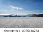 A wide-angle ground with a clear sky and mountainous background for vehicles or products placement
