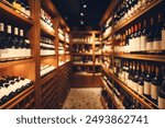 Wide-angle interior shot of big cellar in wine shop with wooden shelves for alcohol drinks. Long corridor of wine collection in elite alcoholic beverages.