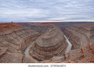 A wide-angle, panoramic view of the deep, winding entrenched meanders of the San Juan River carved into the desert landscape at Goosenecks State Park,