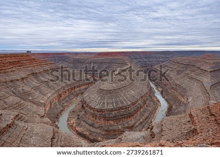 A wide-angle, panoramic view of the deep, winding entrenched meanders of the San Juan River carved into the desert landscape at Goosenecks State Park,