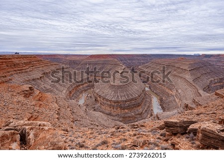 A wide-angle, panoramic view of the deep, winding entrenched meanders of the San Juan River carved into the desert landscape at Goosenecks State Park,