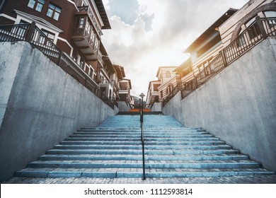 A Wide-angle Shot From The Bottom Of A Colorful Staircase Stretched Into The Vanishing Point, With European Narrow Street In The Distance; Bluish Stairs In Urban Settings Surrounded By Hotel Buildings