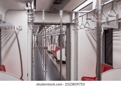 Wide-angle view of an empty subway train showing red seats, handrails, and a CCTV camera sign on the wall. - Powered by Shutterstock