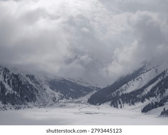 Wide-angle view of a massive alpine valley basin completely buried under heavy winter snow