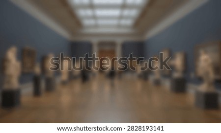 A wide-angle view of a museum interior showcasing classical sculptures and busts arranged on pedestals in a spacious hall.