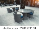 A wide-angle view with a selective focus on the group of empty outdoor wicker cafe tables on the coral sand of a street bar or a hotel restaurant of a luxury Maldives resort