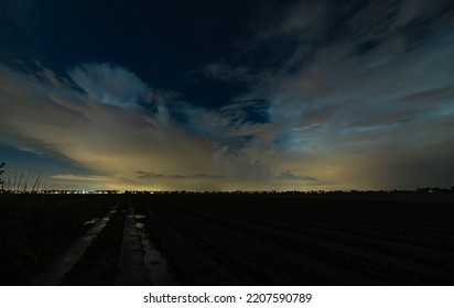 Wide-angle View Of Thundery Showers Over The City Of Rotterdam At Night. The Yellow-orange Glow Is Light Pollution Caused By City Lights And Nearby Greenhouses.