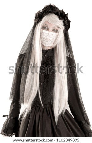 Widow in a black dress with white eyes looking like a doll isolated in white