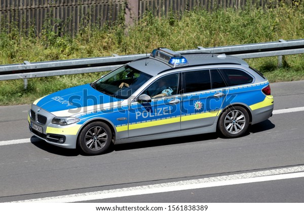 WIEHL, GERMANY - JUNE 25, 2019: North\
Rhine-Westphalia state police car with active blue emergency\
vehicle lighting on\
motorway.