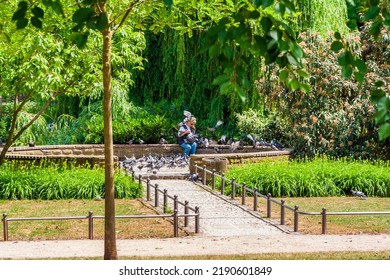 Wiesbaden, Germany - MAY 2011: A Woman Is Covered By Domestic Pigeons (Columba Livia Domestica) While Feeding Them In A Park At Wilhelmstraße, An Urban Boulevard In Wiesbaden, State Capital Of Hesse.