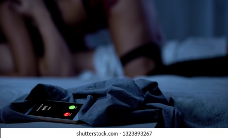 Wife calling while husband making love with mistress, cheating with lover - Shutterstock ID 1323893267