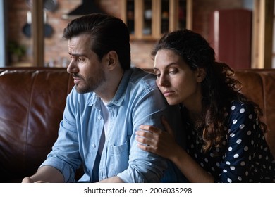 Wife expressing empathy and compassion to sad frustrated husband, going through grief, crisis, sorry for loss, hugging. Woman embracing man, holding shoulders, giving comfort and support