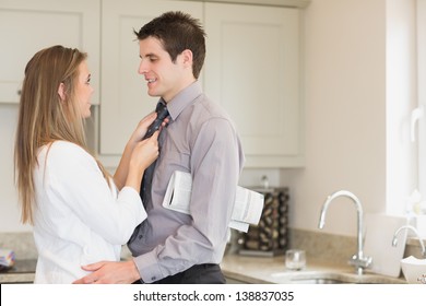 Wife Fixing Husbands Tie In Kitchen