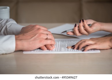 Wife and husband signing divorce (dissolution of marriage) documents, filing divorce papers prepared by lawyer, canceling marriage, performing legal or de jure separation, woman returning wedding ring