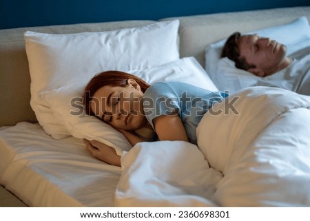 Wife husband sleeping together lying in comfortable bed with white linen at home. Family lifestyle living, happy marriage concept. Spouses man woman living in love, harmony, dreaming, relaxing. 