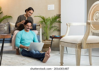 Wife and husband spend time with laptop at home.