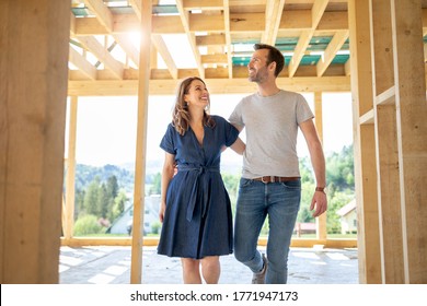 Wife and husband visiting building site of their new house with construction in background