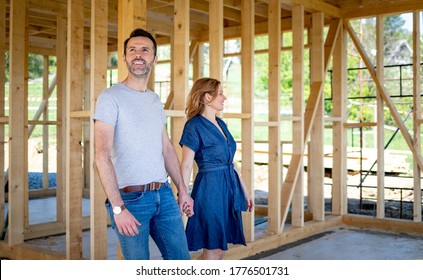 Wife and husband visiting building site of their new house with construction in background