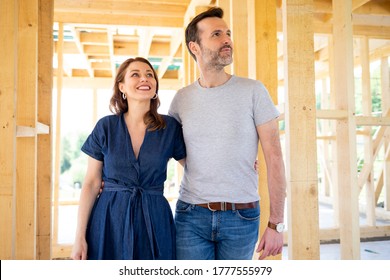 Wife and husband visiting building site of their new house with construction in background - Powered by Shutterstock