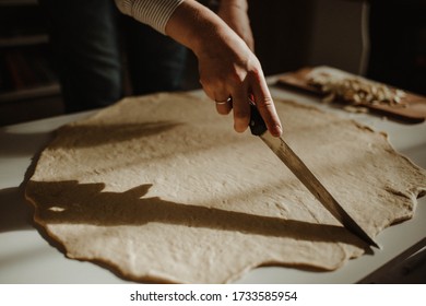 Wife making a homemade doughy pastry food with smoked cheese during Ramadan for dinner during the sunset light in the home on the wooden table - Shutterstock ID 1733585954