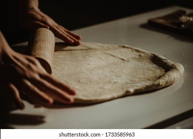 Wife making a homemade doughy pastry food with smoked cheese during Ramadan for dinner during the sunset light in the home on the wooden table - Shutterstock ID 1733585963
