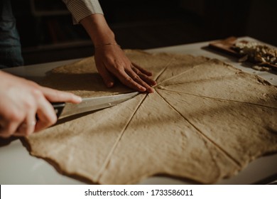 Wife making a homemade doughy pastry food with smoked cheese during Ramadan for dinner during the sunset light in the home on the wooden table - Shutterstock ID 1733586011