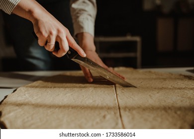Wife making a homemade doughy pastry food with smoked cheese during Ramadan for dinner during the sunset light in the home on the wooden table - Shutterstock ID 1733586014