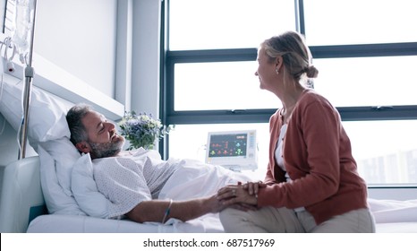 Wife visiting husband in hospital. Woman consoling hospitalised man. - Powered by Shutterstock