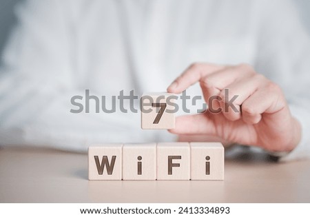 WiFi 7 CERTIFIED. Hand hold wooden cube blocks with WiFi-7 symbol. Transformation technology and upgrade router for high internet speed to support IoT and smartphones. Enhances network performance.