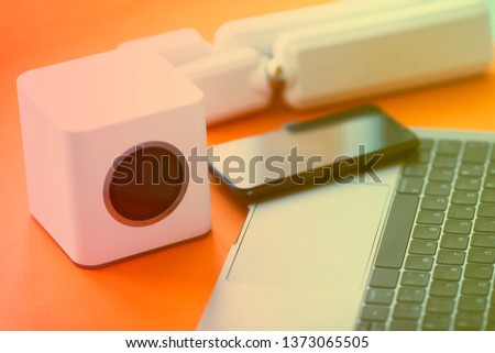 Wifi business concept. Wifi router, access points, mobile phone, laptop, camera and other wireless endpoints on the orange background. Closeup. Space for a text.