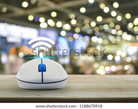 Wi-fi button with wireless computer mouse on wooden table over blur light and shadow of shopping mall, Technology and internet concept