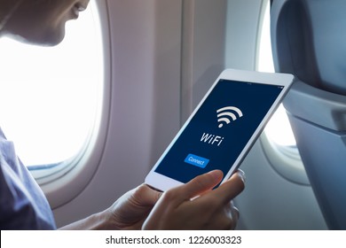 Wifi Internet Access In Airplane During Flight, Passenger Using Tablet Computer To Connect To Wireless Network Technology Onboard To Read Email While Flying