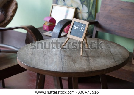 Wifi sign on wood table in public cafe. Natural light.