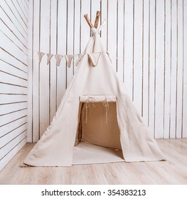wigwam for children in a room with wooden planked walls