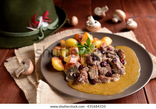 Wild boar meat with roasted potatoes,\
mushrooms and cranberries