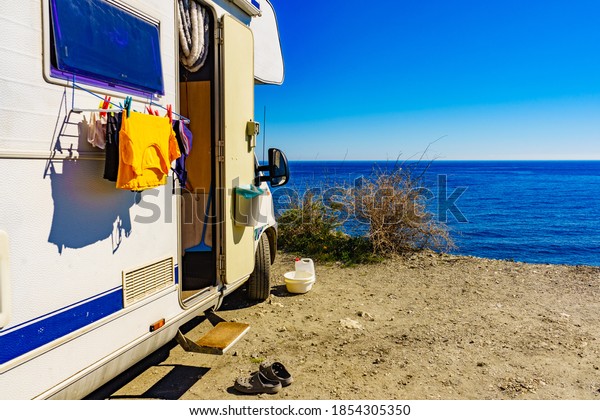 Wild camping on sea shore.\
Camper car rv with clothes hanging to dry. Holidays with motor\
home.