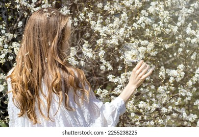 wild cherry blossom tree mother woman with bunny rabbit ears against with baby toddler in arms.girl holding wine glass with small little flowers inside ladybug on edge.sunny easter spring day blonde  - Powered by Shutterstock