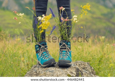 Wild flowers bouquet into the travel shoes. Freedom travel concept. 